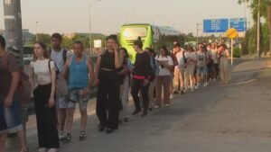 Fila de viajeros en una de las paradas de autobuses de Cuatro Vientos, junto a la A-5